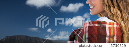 Composite image of smiling beautiful woman wrapped in blanket Composite image of smiling beautiful woman wrapped in blanket 43730829