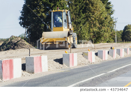 Vibratory soil compactor working on highway construction site. 43734647