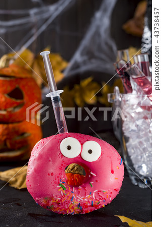 Dishes with glazed donuts, with a red cocktail in a glass tube in a bucket of ice, in the background Dishes with glazed donuts, with a red cocktail in a glass tube in a bucket of ice, in the background 43738457