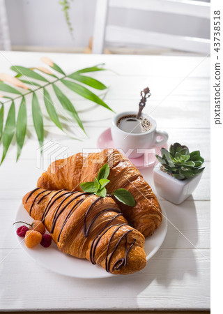 Continental breakfast freshly baked croissant decorated with jam and chocolate on wooden table in a Continental breakfast freshly baked croissant decorated with jam and chocolate on wooden table in a 43738518