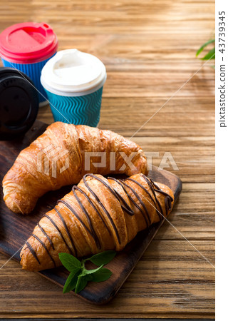 cups of coffee and two croissants on the street in Croissant Cafe. Inscripton on cup - Croissant 43739345