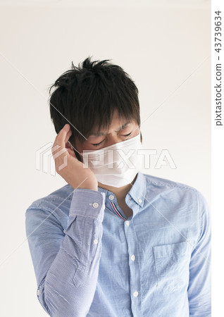 A man suffering from a headache A man suffering from a headache 43739634