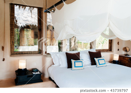 Resort bedroom with wooden bed with mosquito net Resort bedroom with wooden bed with mosquito net 43739797