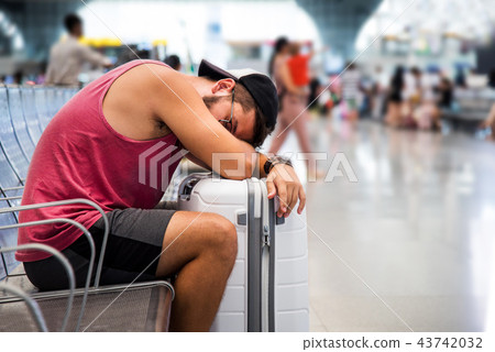 Man sleeping while waiting on the train station Man sleeping while waiting on the train station 43742032