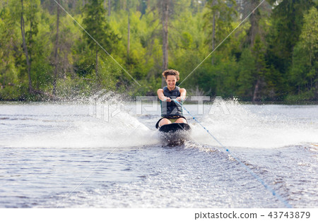 Young athletic woman riding kneeboard on a lake 43743879