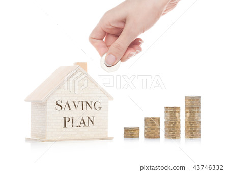 Wooden house model with coins next to it and hand 43746332