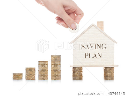 Wooden house model standing on coins and hand Wooden house model standing on coins and hand 43746345
