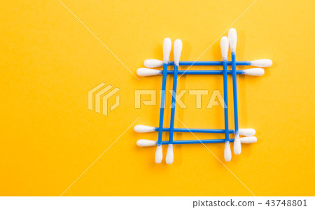 Frame made of blue cotton bud on yellow background 43748801