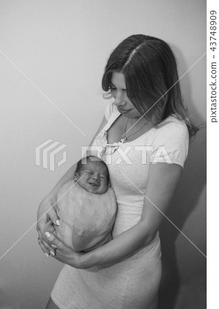 newborn baby in the arms of the mother. newborn baby in the arms of the mother. 43748909