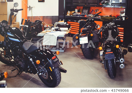 Many motorcycles on the floor with workshop  43749066
