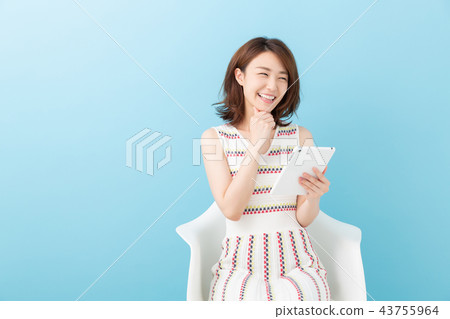 觀看一種片劑的婦女在屋子裡 觀看一種片劑的婦女在屋子裡 43755964