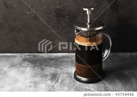 Coffee in french press on dark background Coffee in french press on dark background 43759498