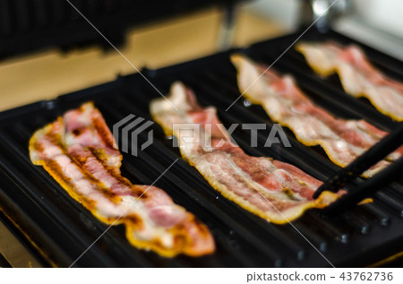 thin slices of delicious bacon fried on the grill thin slices of delicious bacon fried on the grill 43762736