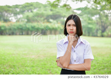 Education Concepts. Beautiful young Asian girl is thinking serio Education Concepts. Beautiful young Asian girl is thinking serio 43764029