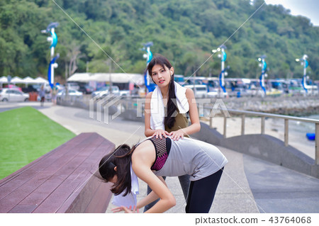 Sports concept. Beautiful girl is exercising on the beach with w Sports concept. Beautiful girl is exercising on the beach with w 43764068