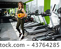 Girl standing in the gym holds a mat 43764285