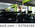 A girl doing sit-ups in the gym 43764288