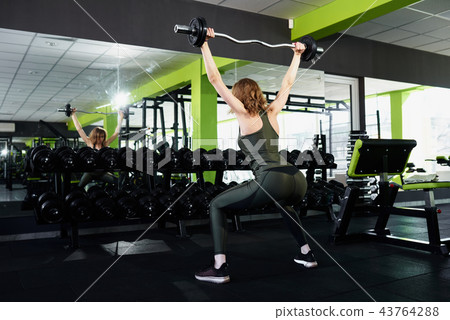 A girl doing sit-ups in the gym A girl doing sit-ups in the gym 43764288