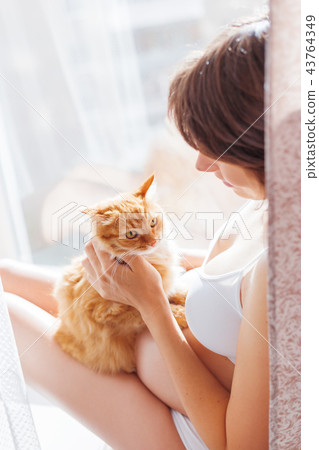 Pregnant woman with cute ginger cat. Pregnant woman with cute ginger cat. 43764349