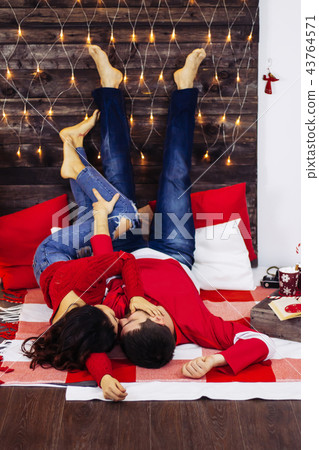 couple lay down next new years tree red pullover couple lay down next new years tree red pullover 43764571