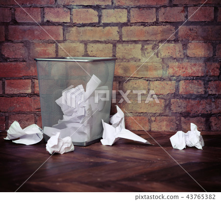 Recycle bin filled with crumpled papers. 43765382