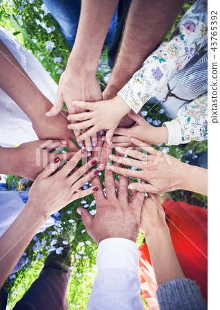 Group of friends with their hands in a circle Group of friends with their hands in a circle 43765392