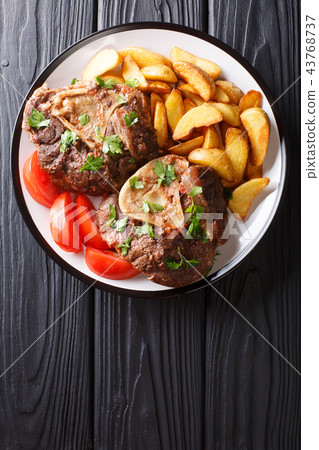 shank Ossobuco with a garnish of fried potato 43768737