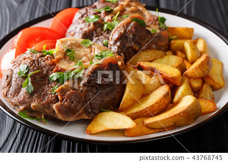Spicy steak Ossobuco with fried potato wedges 43768745