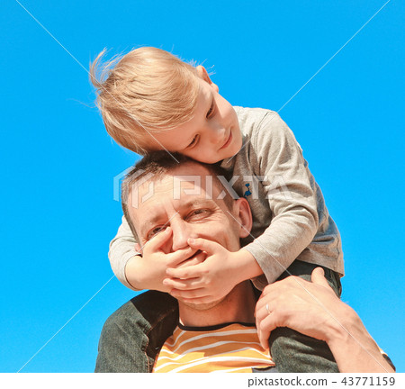 child shoulders father plays hands closing eyes 43771159