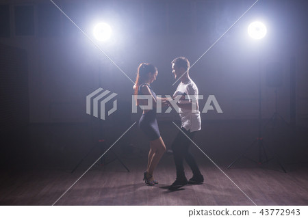 Young couple dancing latin dance Bachata, merengue, salsa. Two elegance pose in dance class Young couple dancing latin dance Bachata, merengue, salsa. Two elegance pose in dance class 43772943