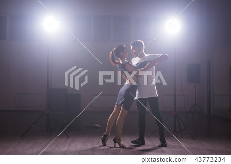 Young couple dancing social danse kizomba or bachata or semba or taraxia in dancing class background 43773234