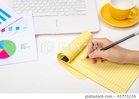 A note taking notes on a notepad in an office A note taking notes on a notepad in an office 43773239