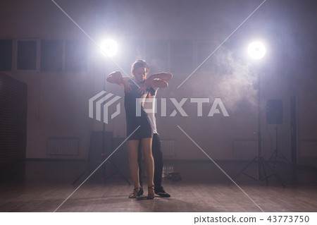 Young couple dancing social danse kizomba or bachata or semba or taraxia in dancing class background Young couple dancing social danse kizomba or bachata or semba or taraxia in dancing class background 43773750