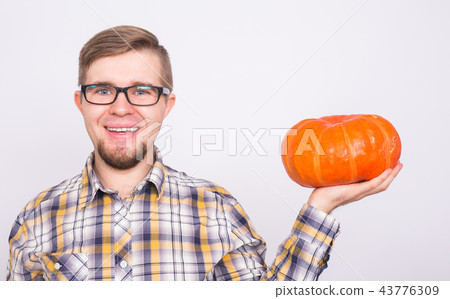 Smiling man holding pumpkins over white background - harvest and autumn concept Smiling man holding pumpkins over white background - harvest and autumn concept 43776309