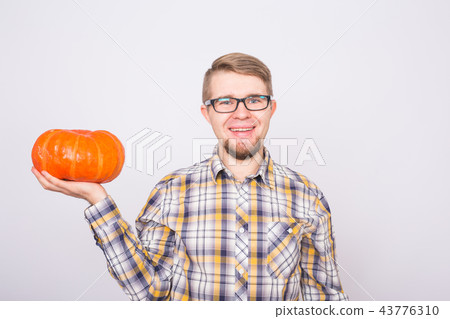 portrait of a young farmer holding a pumpkin on white background portrait of a young farmer holding a pumpkin on white background 43776310