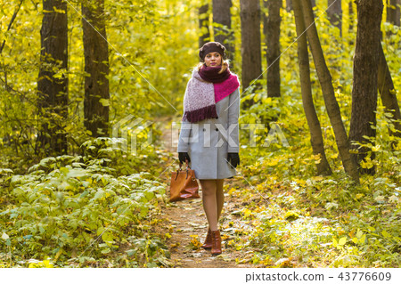 Young stylish woman walking in autumn park Young stylish woman walking in autumn park 43776609