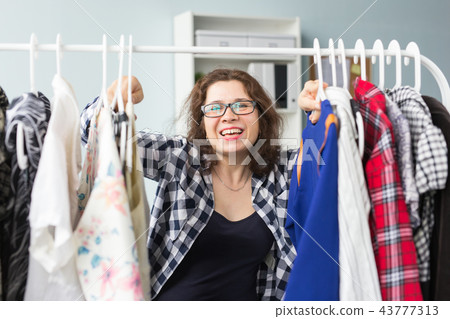 Happiness, clothes, people concept- a happy woman enjoying her wardrobe Happiness, clothes, people concept- a happy woman enjoying her wardrobe 43777313