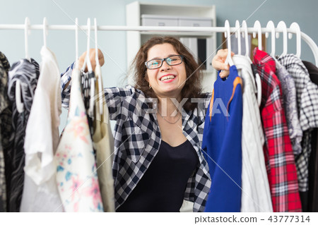 Fashion, style and people concept - woman choosing clothes in front of full closet Fashion, style and people concept - woman choosing clothes in front of full closet 43777314