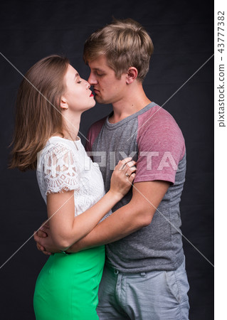 Lovers kissing each other on black background Lovers kissing each other on black background 43777382