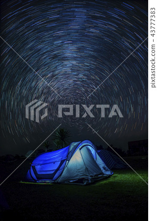 Tourist near his camp tent at night under a sky fu Tourist near his camp tent at night under a sky fu 43777383