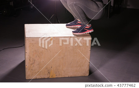 Young woman jumping on box at a crossfit gym. 43777462