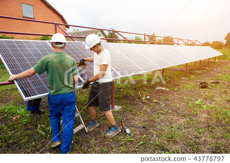 Installation of stand-alone exterior photo voltaic panels system. Renewable green energy generation. 43778797