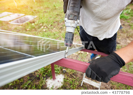Installation of stand-alone exterior photo voltaic panels system. Renewable green energy generation. 43778798