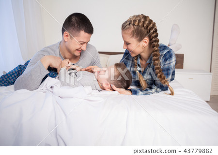mom dad and son in the morning in the bedroom on the bed 43779882