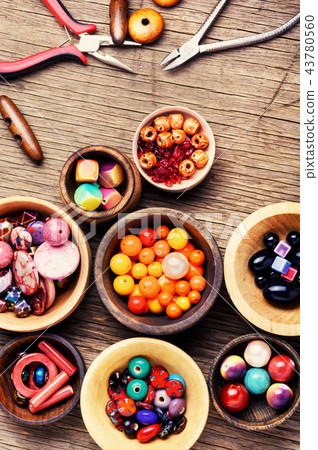 Colorful beads in wooden bowls Colorful beads in wooden bowls 43780560