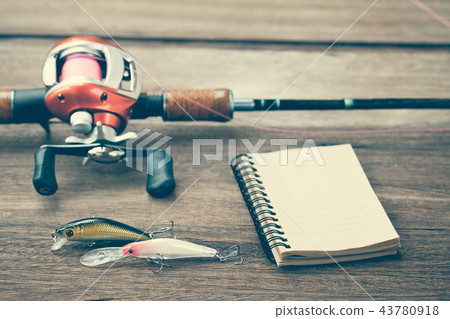 Fishing tackle - Baitcasting Reel, book on wooden Fishing tackle - Baitcasting Reel, book on wooden 43780918