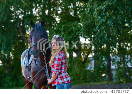 Beautiful girl with long hair on a walk with a horse. Summer cool evening. 43781787