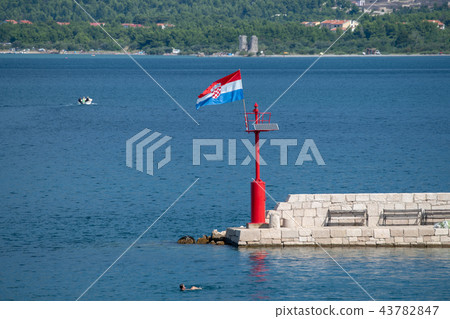 Croatian flag flying in wind on lighthouse in harbor Croatian flag flying in wind on lighthouse in harbor 43782847