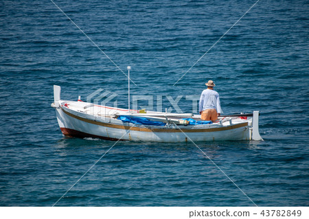 Fisherman in traditional wooden boat at sea Fisherman in traditional wooden boat at sea 43782849