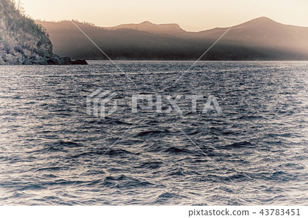 the sunrise in the ocean near the mountain 43783451